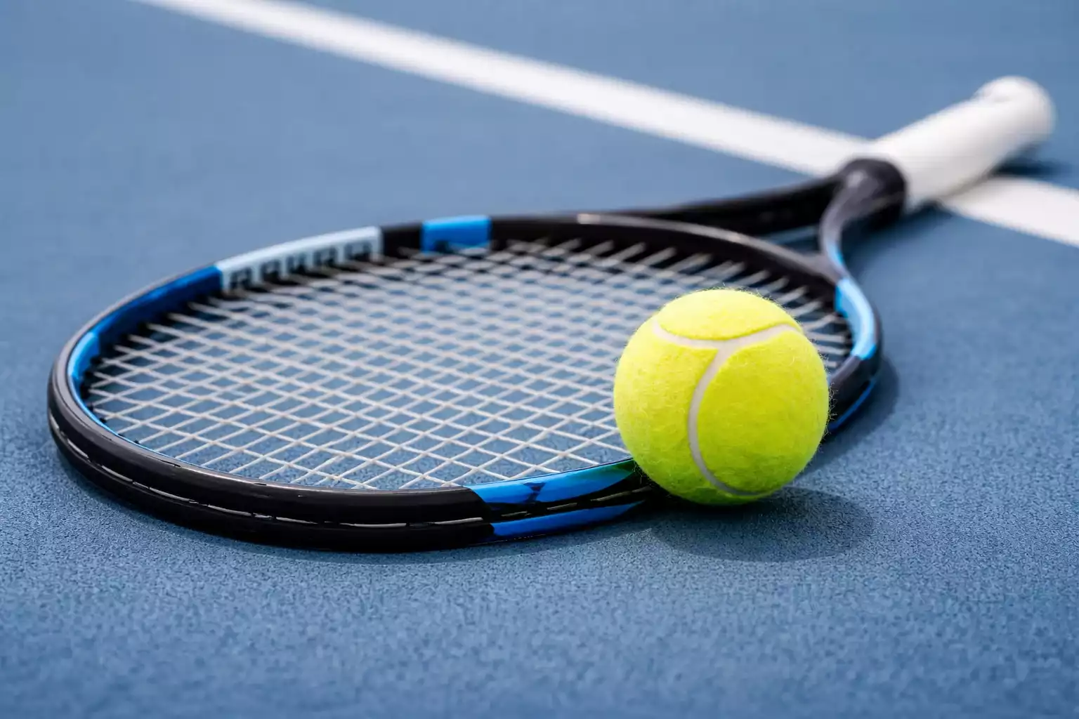 Primo piano di una racchetta da tennis e palla sul campo